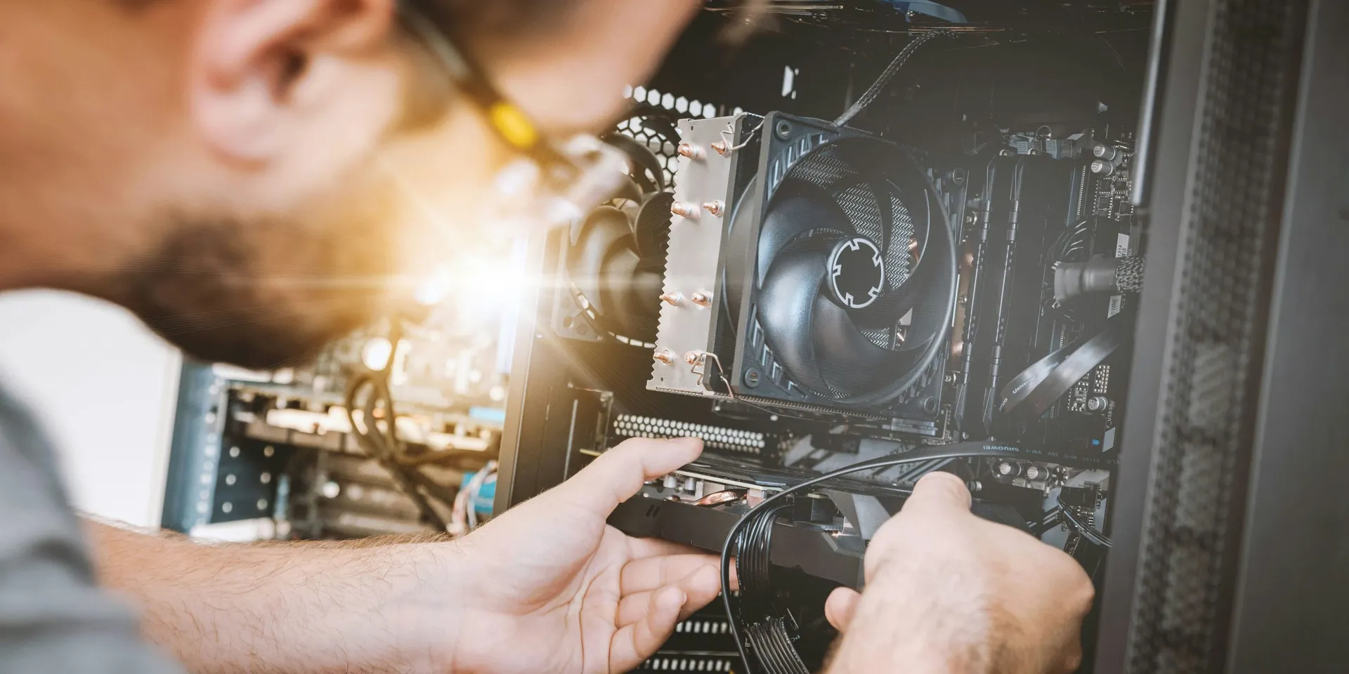 A technician working inside a desktop computer during a repair